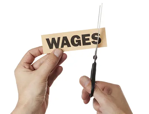 hand with scissors cutting into a label signed "wages"
