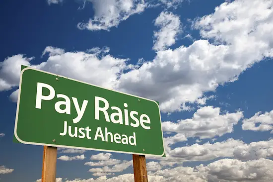 Image of road sign with words 'pay raise just ahead'