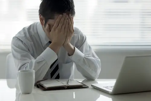 Image of stressed employee at desk