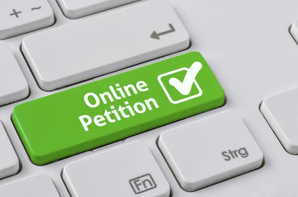 A keyboard with a green button - Online Petition