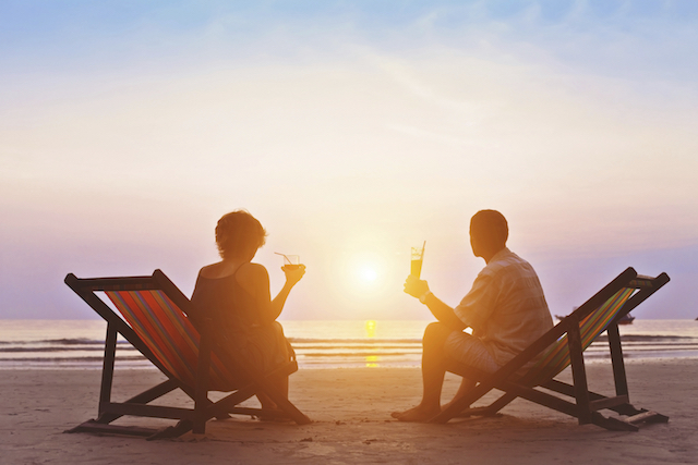 Couple enjoying the sunset in beach chairs
