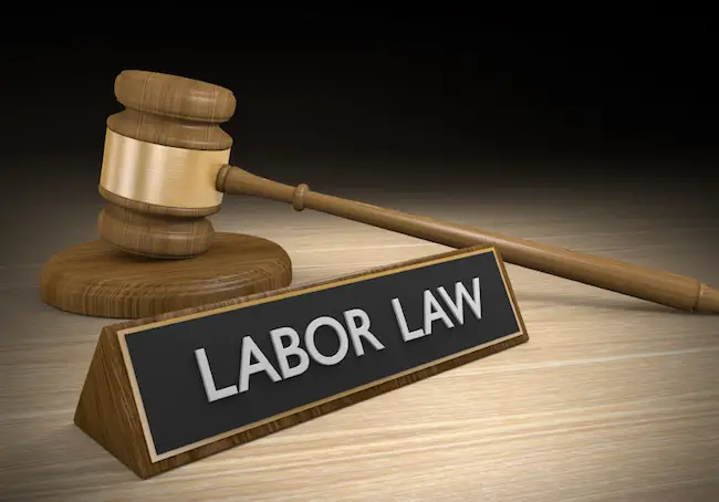 Image of gavel beside desk sign that says 'labor law'