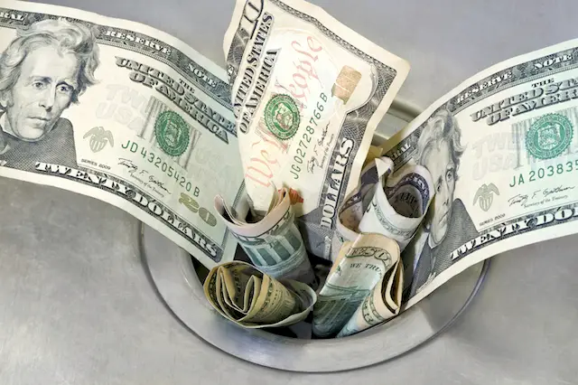 Image of cash going down a drain