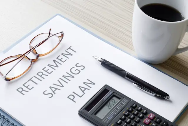 Image of retirement savings plan workbook on a desk with calculator