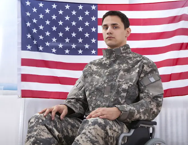 Image of soldier sitting in wheel chair against an American flag