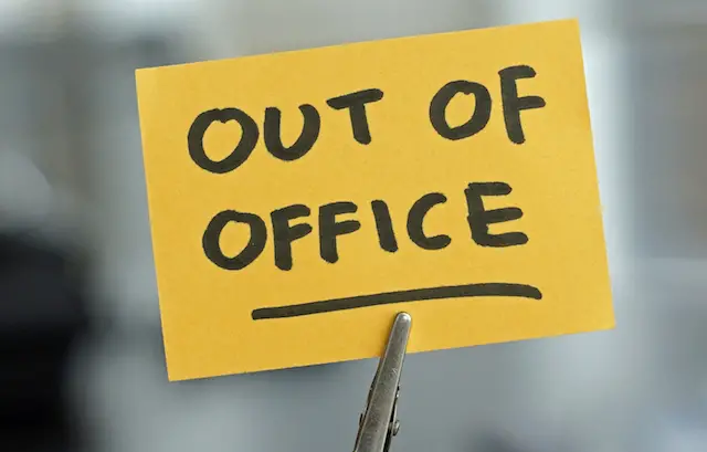 Out of office written on a card at the desk