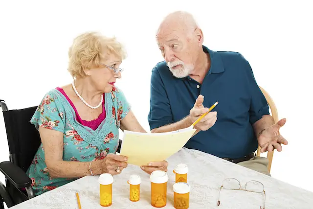 Senior couple at the dining room table discussing medical and prescription costs