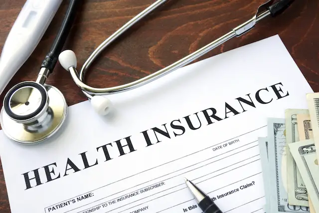 Health insurance form and dollars on the table