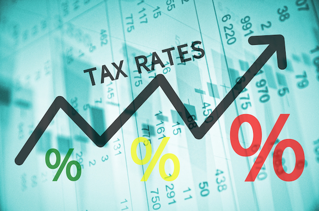 Text Tax rates on up trend arrow, with financial data visible on the background