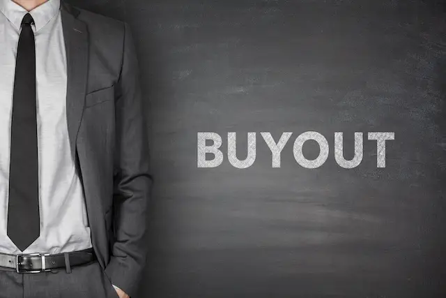 Image of word 'buyout' on blackboard with businessman on side