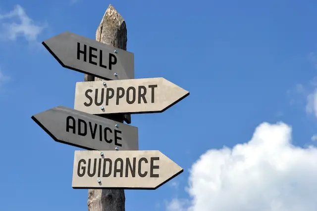 Wooden singpost with "help, support, advice, guidance" arrows against blue sky