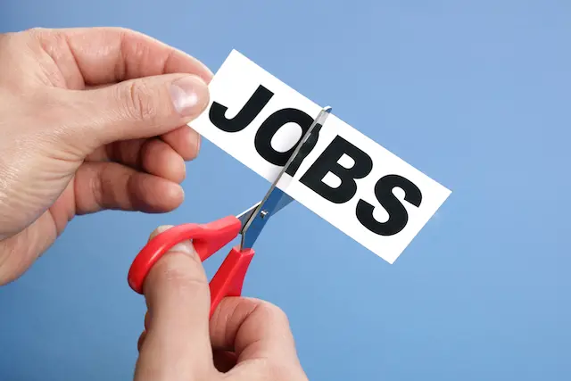 Image of a hand with scissors cutting through the word 'jobs'