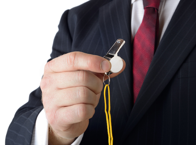 Businessman holding a whistle - whistleblower concept