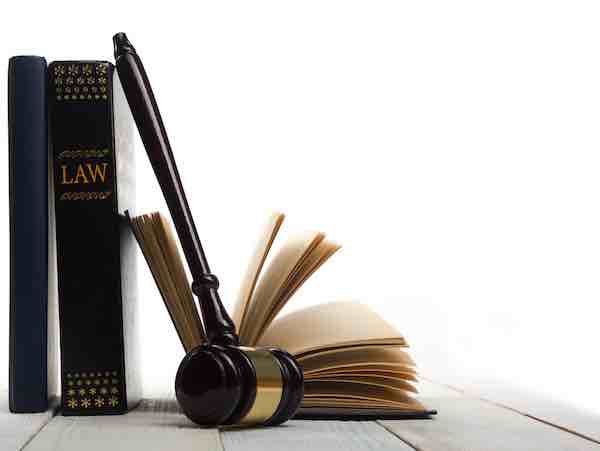 Law book with a wooden judge's gavel on a desk