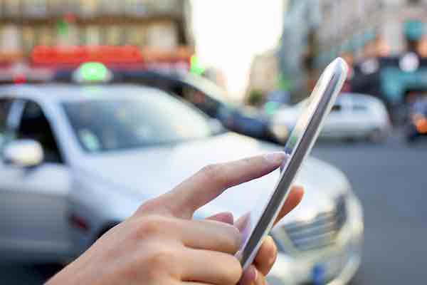 Woman ordering a ride sharing service from her smartphone