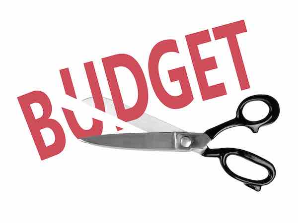 Scissors cutting through the word 'budget'