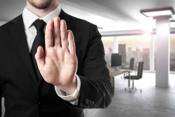 businessman holding up hand in stop gesture