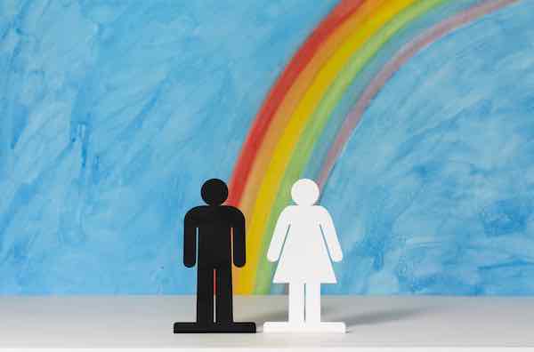 Man and women icons with a rainbow and blue sky to illustrate the concept of gender equality