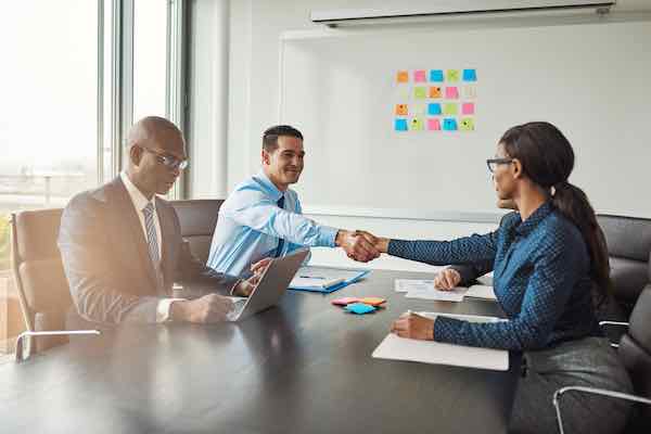 Two business colleagues shaking hands across the table