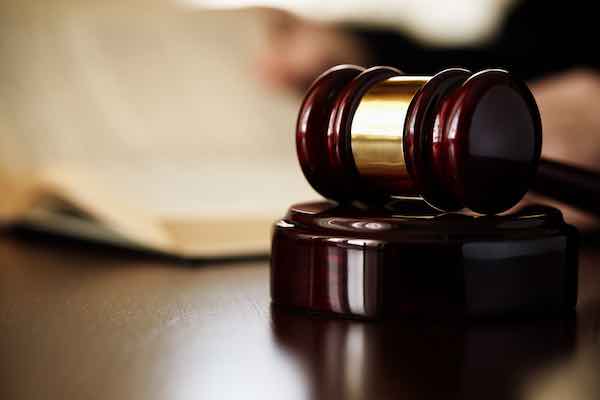 Close up of a judge's gavel on a desk with a law book in the background