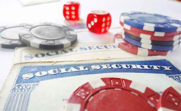 Social Security card on a table with dice and poker chips