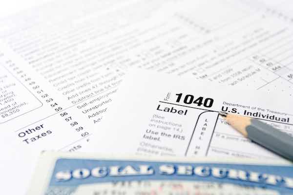 Social Security card on US 1040 tax forms with gray pencil