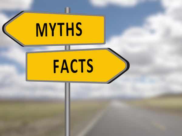 Road sign with two yellow arrows pointing in opposite directions, one labeled 'myths' and one labeled 'facts'