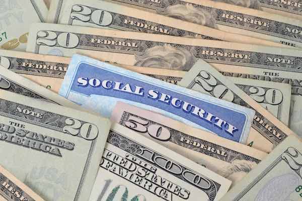 Social Security card stuck in the middle of a pile of cash