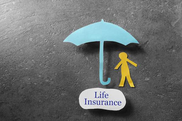 Paper cutouts of a person under an umbrella next to the words 'life insurance'