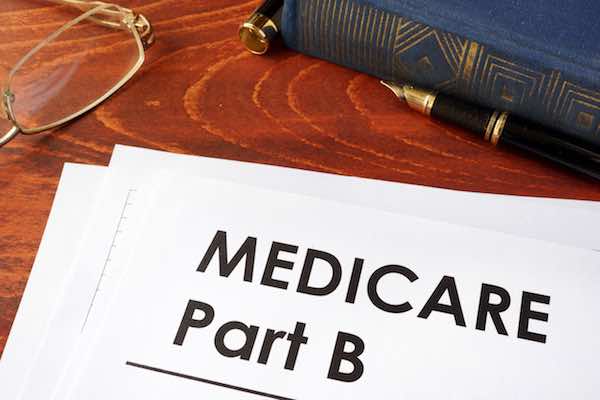 Document labeled 'Medicare Part B' on a desk with glasses and pen