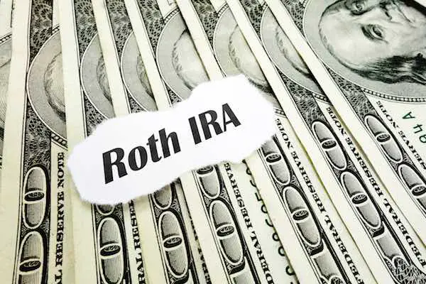 Words 'Roth IRA' on a spread of hundred dollar bills
