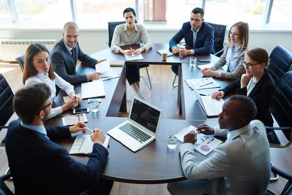 Businespeople conducting negotiations at a conference table in an office setting