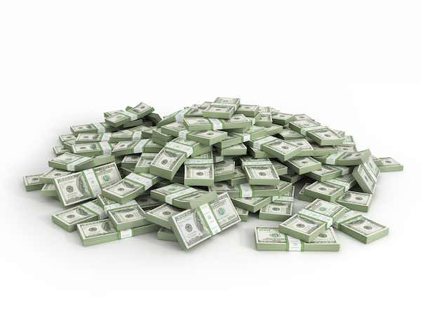 Packs of hundred dollar bills scattered into a large pile against a white background