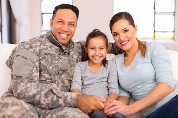Young military family sitting on the couch at their home