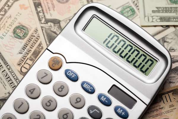 Close-up of calculator sitting on top of cash with one million on the display