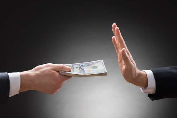 Close-up of businessman's hand rejecting the money offered by another businessman