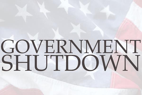 Words 'government shutdown' overlaid on the backdrop of an American flag