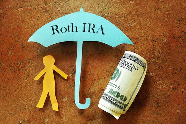 Paper cutout of a person under an umbrella labeled 'Roth IRA'