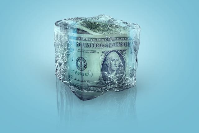 US dollars frozen in a block of ice depicting a pay freeze