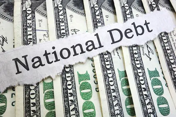 headline reading 'national debt' overlaid on a spread of $100 bills