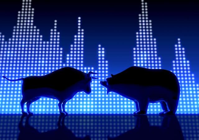 Silhouette of a bull and bear against an LED stock chart background