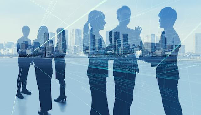 Silhouettes of businesspeople overlaid against a city skyline