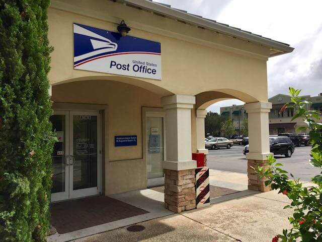 Customer entrance to Post Office building showing the United States Postal Service logo on the awning over the doorway