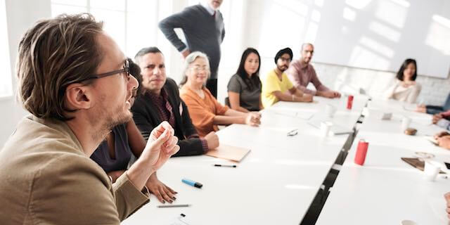 Group of employees around a conference room table engaged in collective bargaining/negotiations