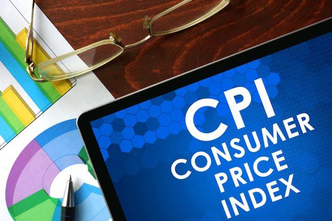 Close up of laptop screen with text on display 'CPI Consumer Price Index' on a desk next to papers with graphs and charts