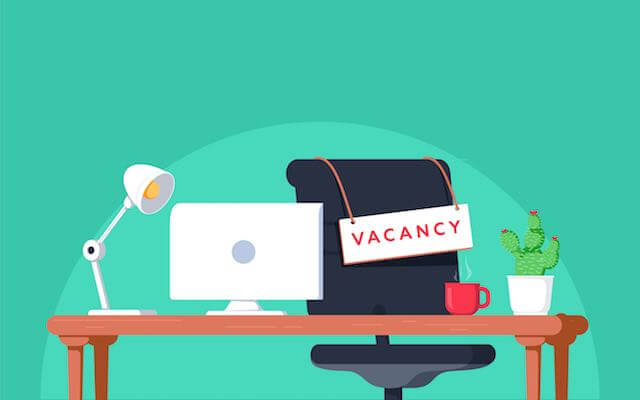 Illustration of an employee's workstation/desk with a 'vacancy' sign hanging on the office chair