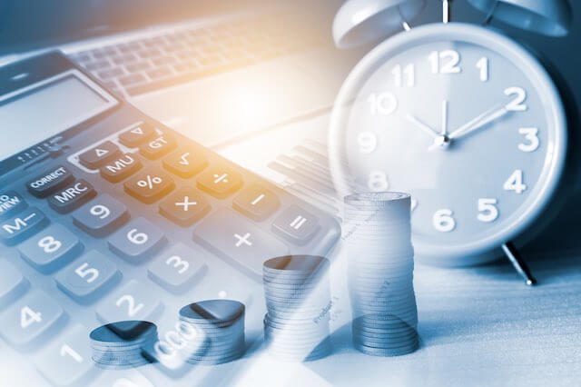 Blended image of an old style alarm clock, calculator and growing stacks of coins in a row depicting growth of retirement savings over time/time is money concept