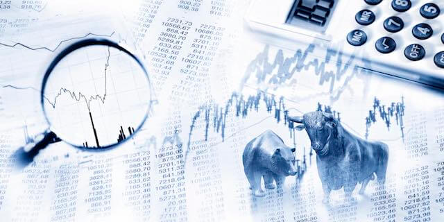 Stock market graphs with a magnifying glass and bull and bear indicating stock market volatility/finance/investments