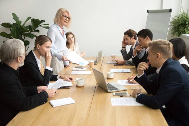 Group of employees around a table in a conference room in negotiations - labor relations/bargaining/unions