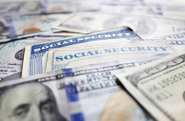 Social Security cards interspersed with cash